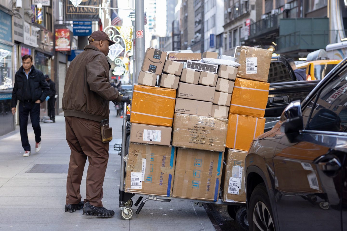 A UPS employee pulls a cart full out packages.