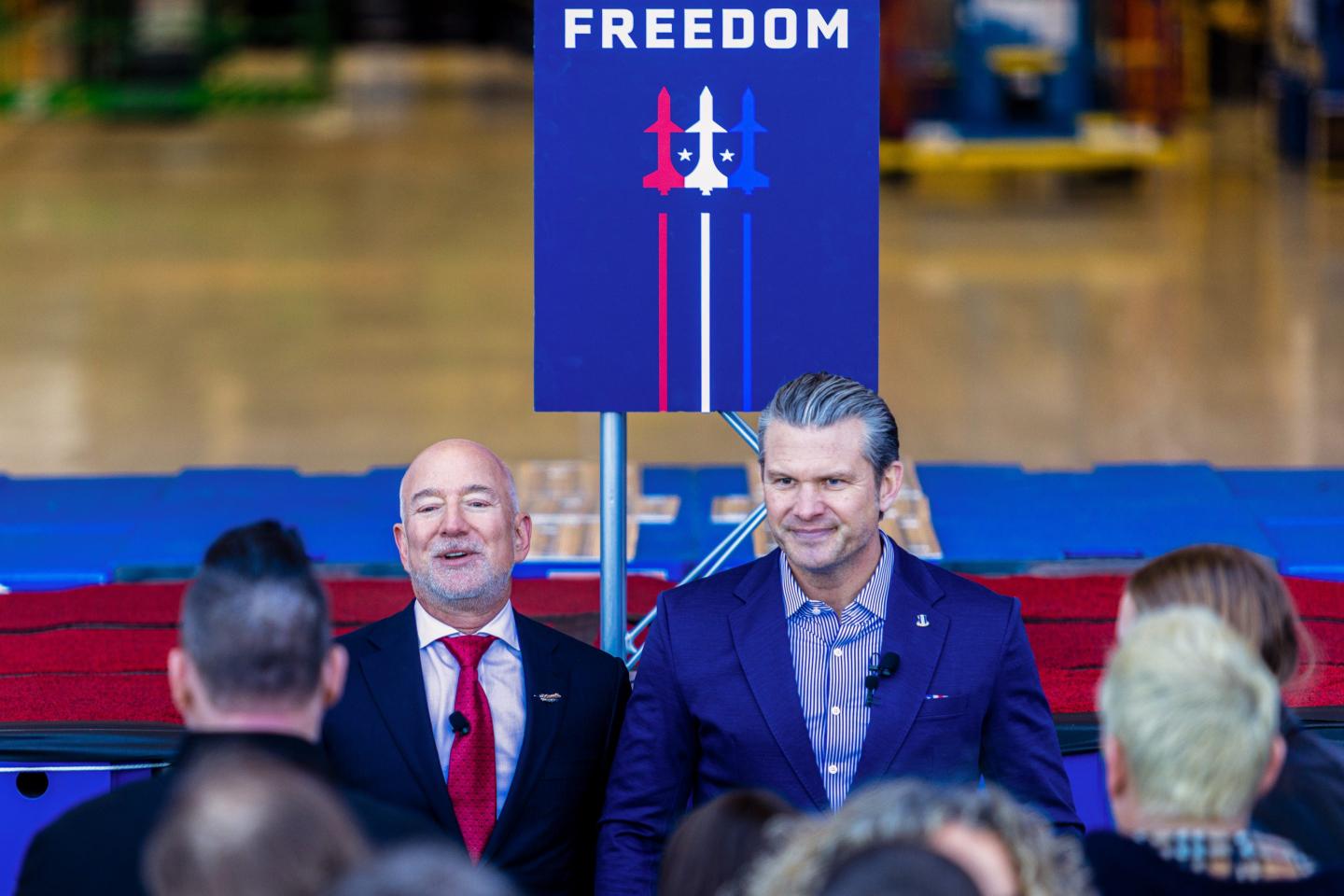 Photo of Jeff Bezos (left) and Pete Hegseth before a sign that reads Freedom