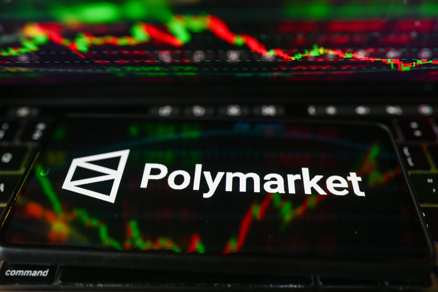 POLAND - 2026/03/16: In this photo illustration, the Polymarket logo is displayed on a smartphone with stock market percentages in the background. (Photo Illustration by Omar Marques/SOPA Images/LightRocket via Getty Images)