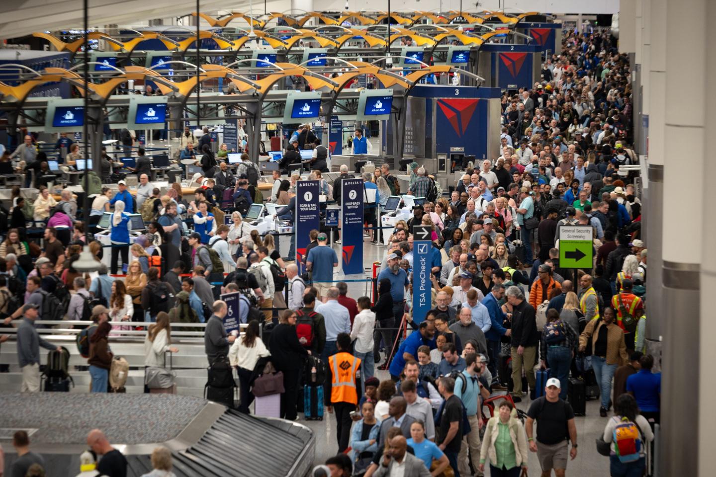 People wait in long lines at the airport.