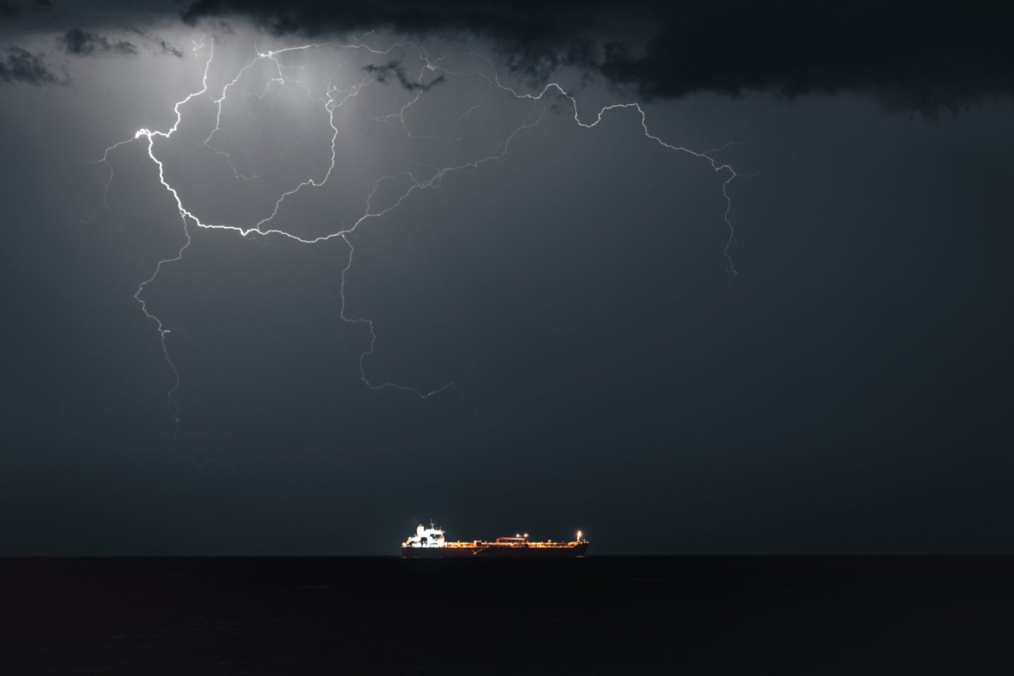 MUSCAT, OMAN - MARCH 21: Lightning occurs when META 4, an Oil Products Tanker, sails into Muscat Anchorage on March 21, 2026 at Sultan Qaboos Port in Muscat, Oman. President Donald Trump had threatened to attack Iran's energy infrastructure if it did not end its de facto blockade of the Strait of Hormuz by just before midnight GMT of March 23. A subsequent statement from President Trump said the U.S. and Iran had held "very good and productive conversations regarding a complete and total resolution of our hostilities in the Middle East," and that he would postpone any attacks on Iranian energy infrastructure for five days. Maritime traffic through the strait, which conveys about 20% of the world's oil and gas, has mostly come to a halt after the joint U.S.-Israeli war with Iran that began on February 28. (Photo by Elke Scholiers/Getty Images)