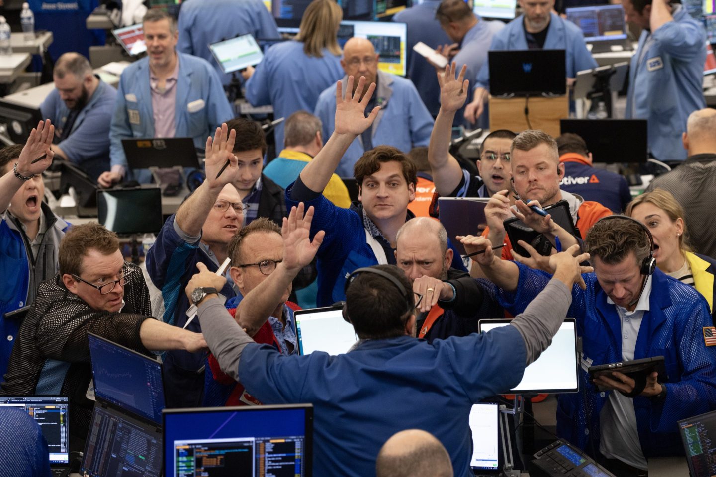 Traders signal offers in the S&amp;P options trading pit at the Cboe Global Markets exchange on March 31, 2026 in Chicago, Illinois.