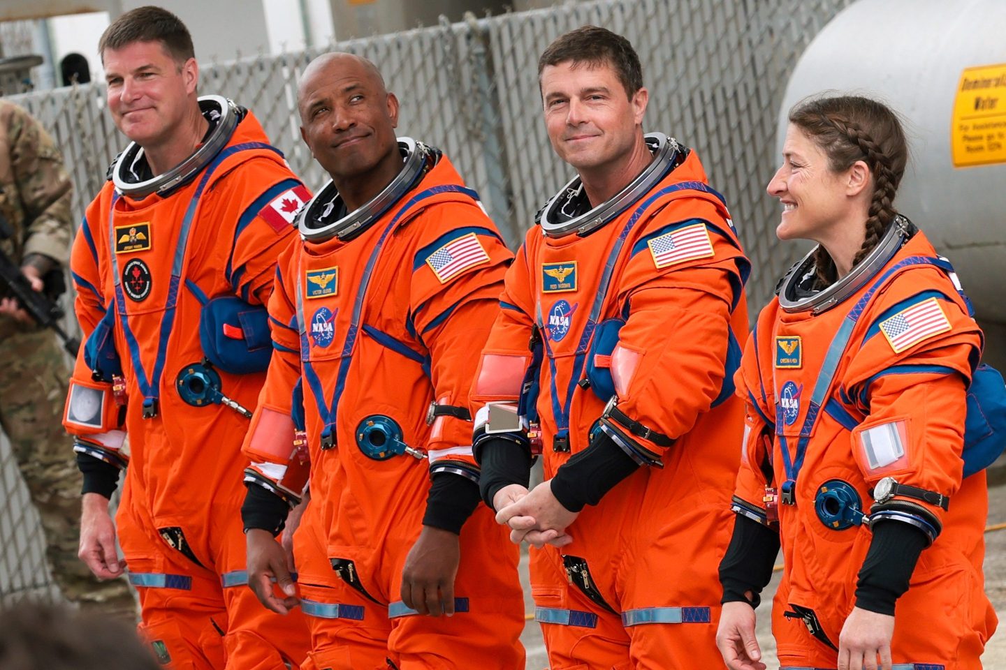 Artemis II astronauts wearing their orange suits.