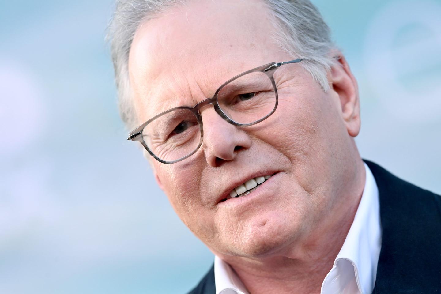Man with glasses in a suit smiling