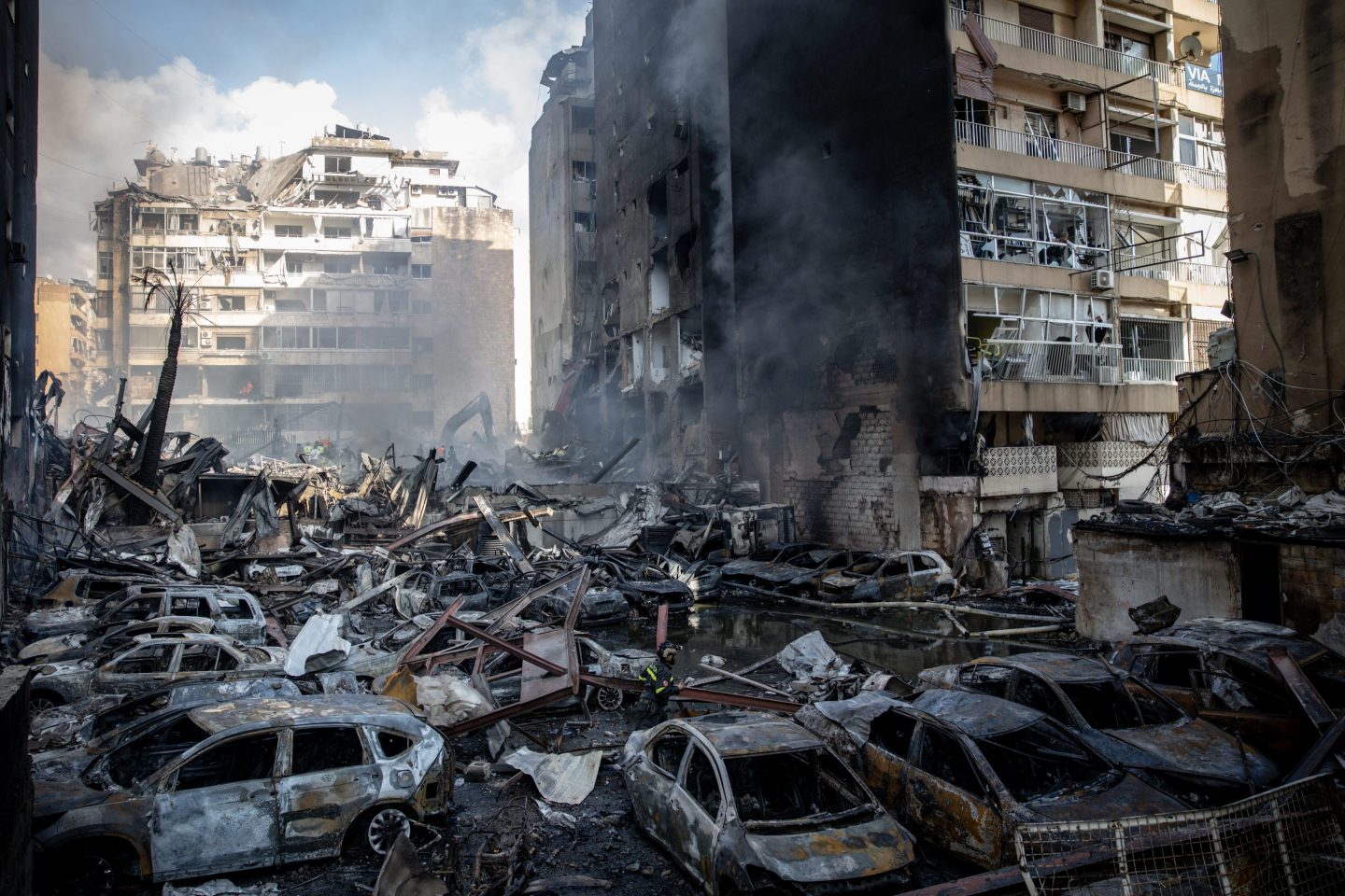 BEIRUT, LEBANON - APRIL 08: A firefighter walks through destroyed cars as a building burns after an Israeli airstrike on April 08, 2026 in Beirut, Lebanon. Israel has stepped-up its attacks on Lebanon following President Donald Trump's announcement of a two-week ceasefire agreement between the US and Iran, conditional on shipping being allowed to resume through the Strait of Hormuz. Israel says it will observe the ceasefire with Iran but insists Lebanon was not included in the deal, and has since launched the "largest coordinated strike" on Hezbollah targets since the cross-border war began on March 2. Iran and Pakistan - which has been coordinating peace talks - have said that the ceasefire would include Lebanon, while the US has yet to weigh-in. (Photo by Chris McGrath/Getty Images)