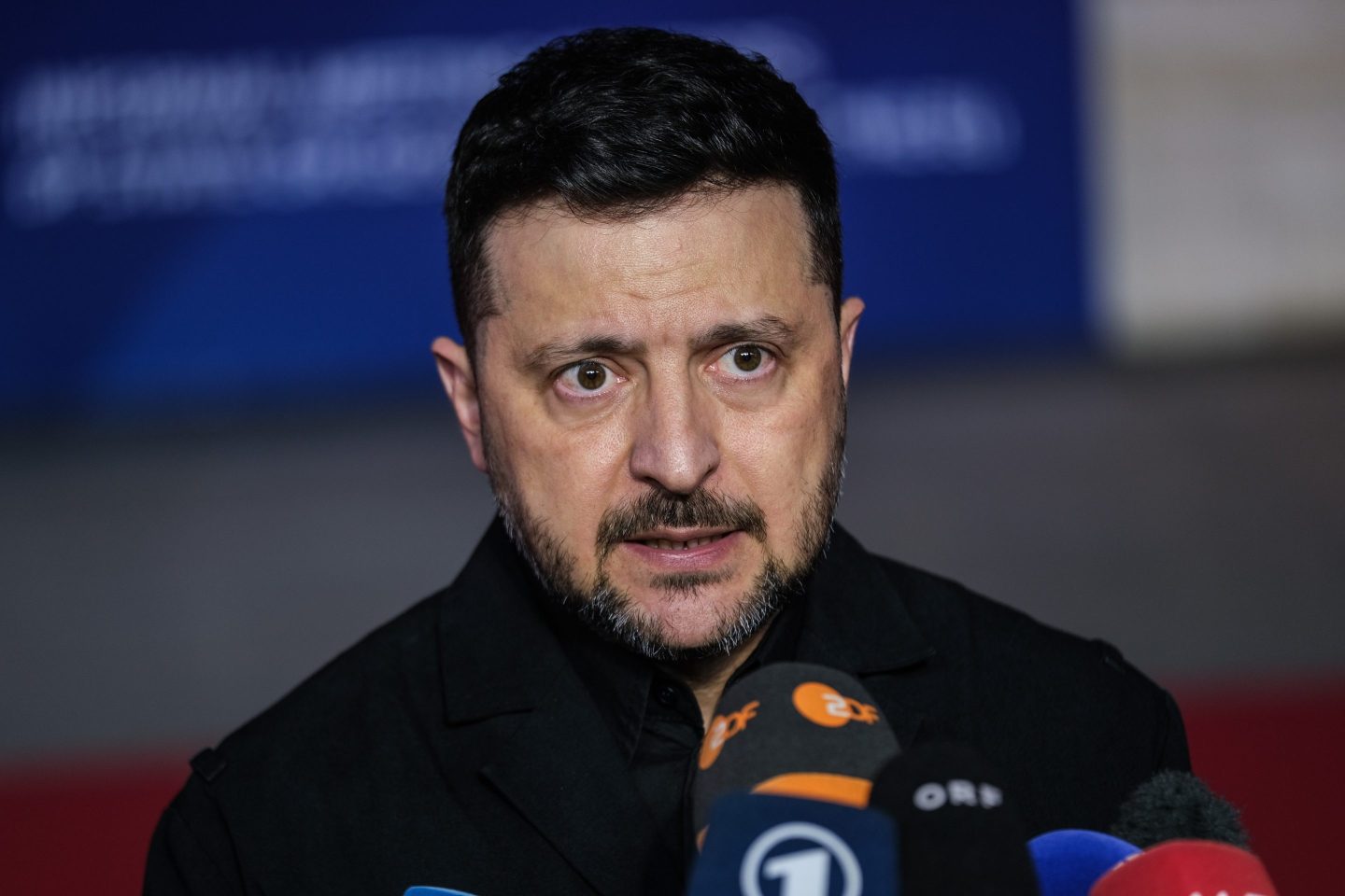 Zelenskyy speaks into several microphones