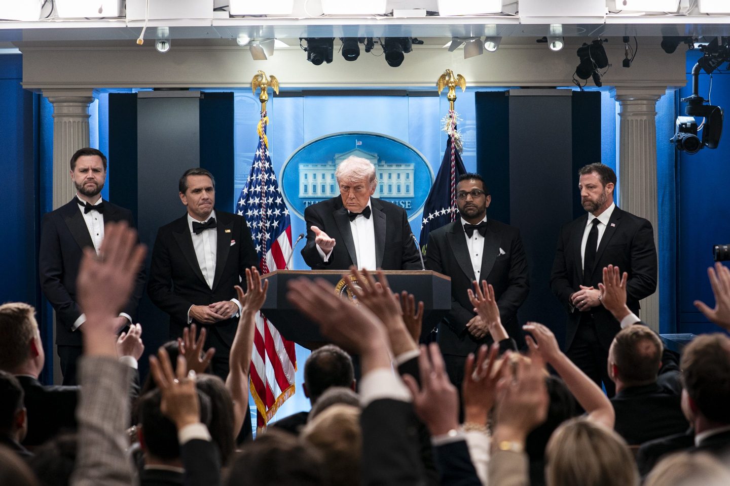 Trump points while flanked by men in suits
