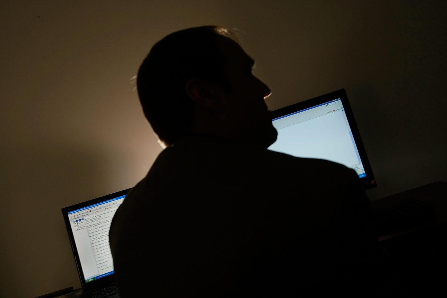 man silhouette two computer screens