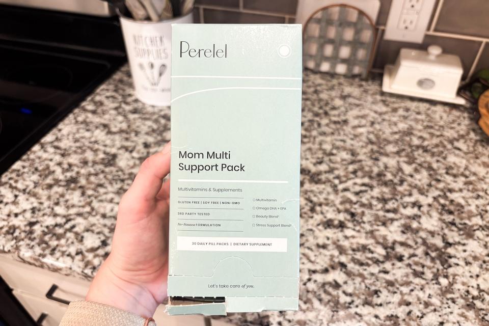 A hand holding a box that reads Perelel Mom Multi Support Pack.