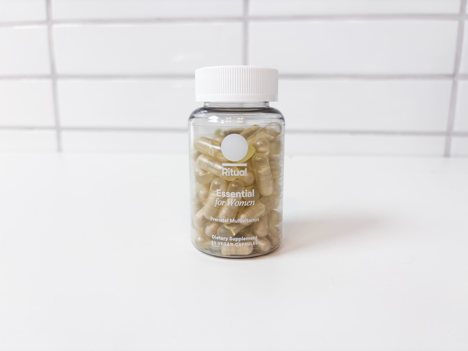 A bottle of Ritaul Prenatal Vitamins sitting on a white countertop.