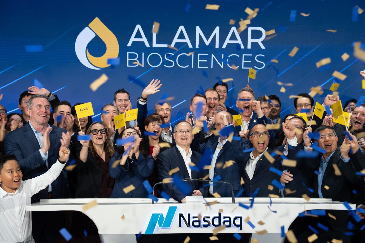 Alamar team rings the closing Nasdaq bell while confetti falls.