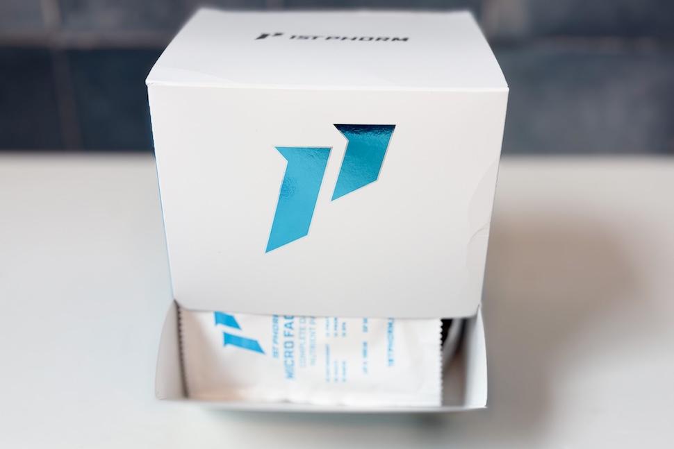 A box of 1st Phorm Micro Factor. The bottom is open, exposing the packets of capsules within.