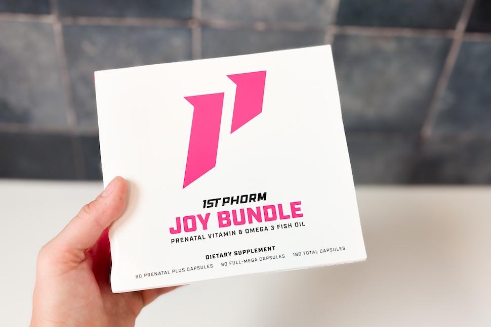 A hand holding up the 1st Phorm Joy Bundle box