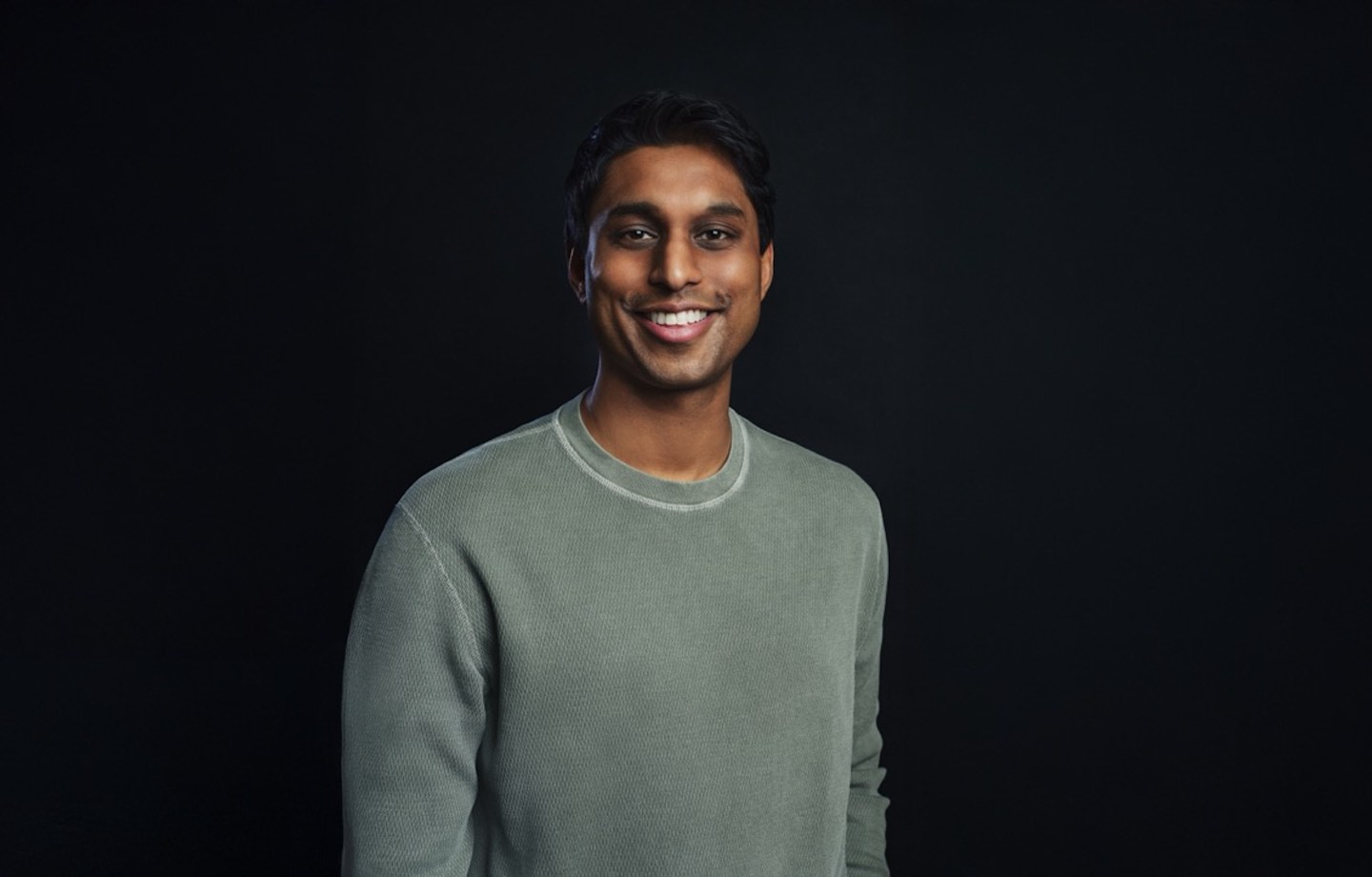 Ankur Jain smiles in a green long sleeve shirt