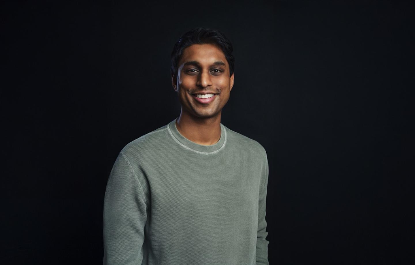 Ankur Jain smiles in a green long sleeve shirt
