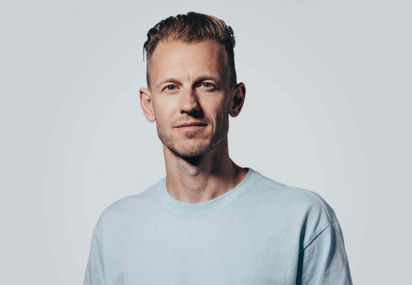 Carl Fritjofsson smiles in a blue t-shirt