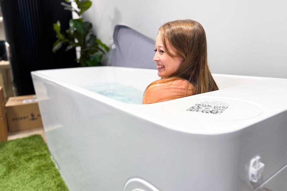 A woman sitting in the Plunge All-In tub and smiling.