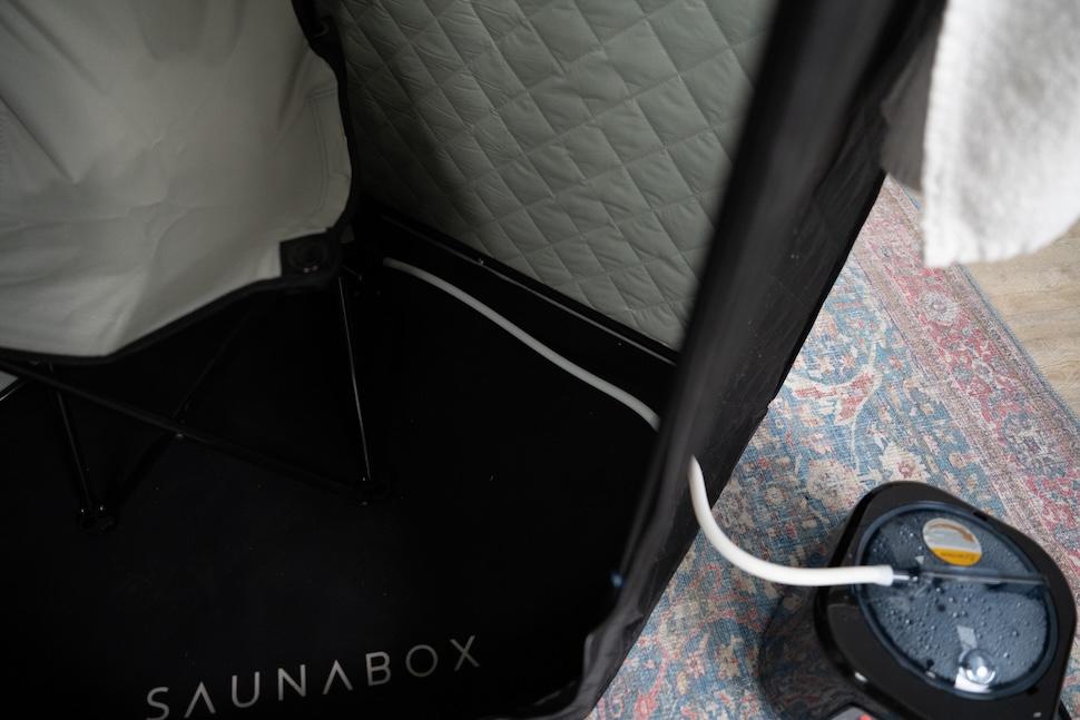 The interior of the Sauna Box. A cord is running out of the exterior to connect to the power source.