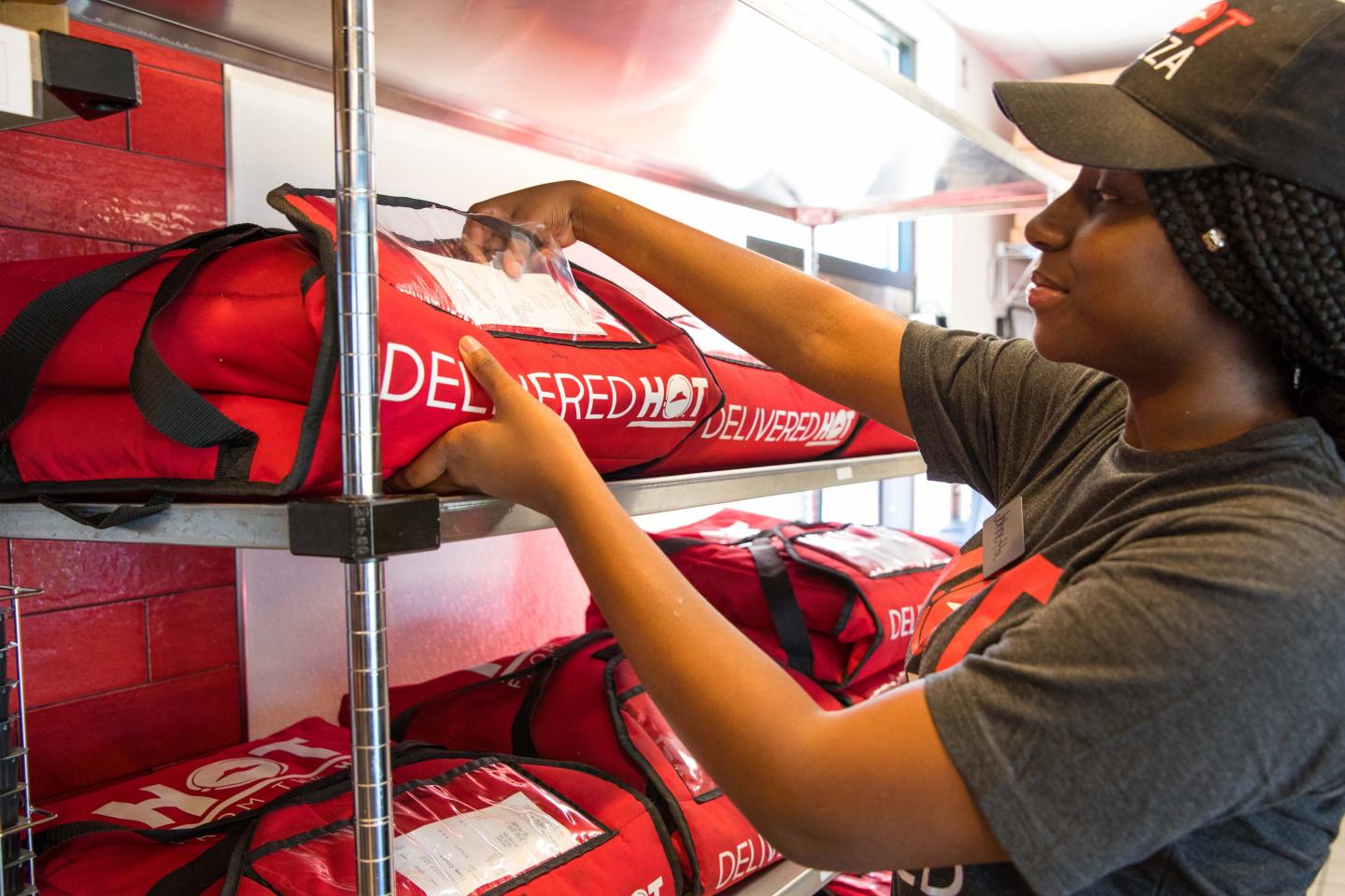 A Pizza Hut workers prepares an order for delivery.