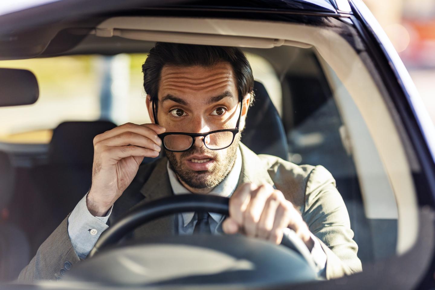Man driving and looking shocked.