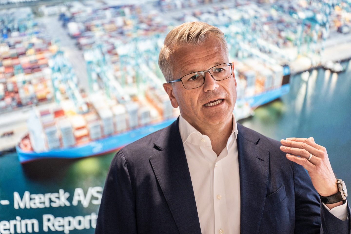 Vincent Clerc speaks in front of a picture of a port.