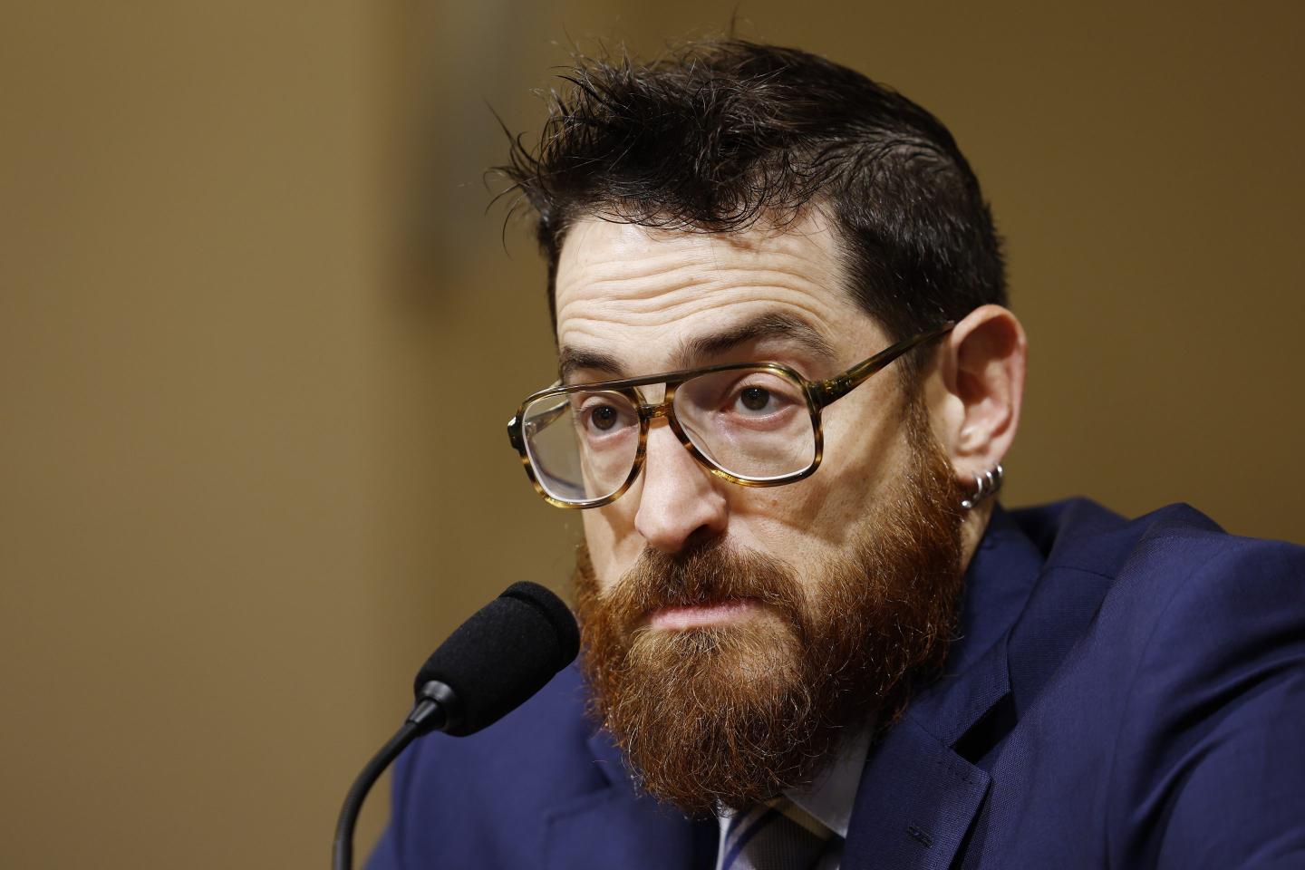 Man with glasses and beard before a microphone