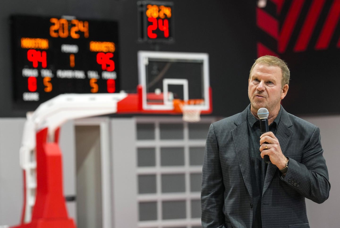 Fertitta stands on an inside basketball court and speaks into a microphone