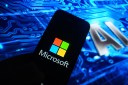In this photo illustration, a Microsoft logo is displayed on a smartphone with Artificial Intelligence (AI) symbols on the background.