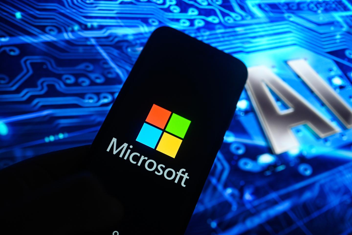 In this photo illustration, a Microsoft logo is displayed on a smartphone with Artificial Intelligence (AI) symbols on the background.