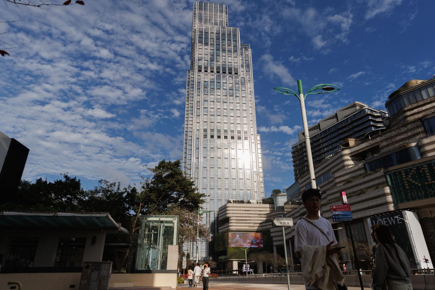 People walk past Rosewood Hong Kong, a luxury hotel under New World Development.