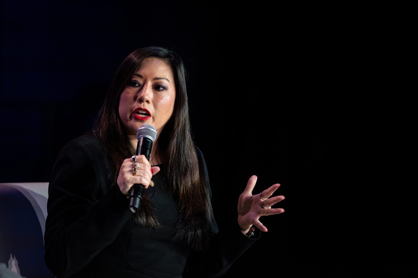 MoonPay chief legal officer and chief administrative officer Caroline Pham holds a microphone and speaks during a crypto conference