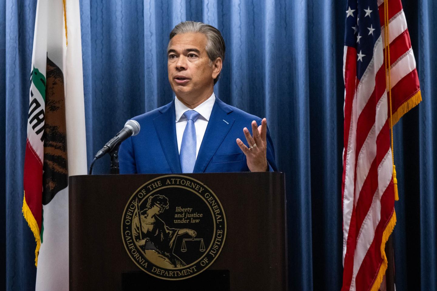Bonta stands at podium and gestures with one hand.