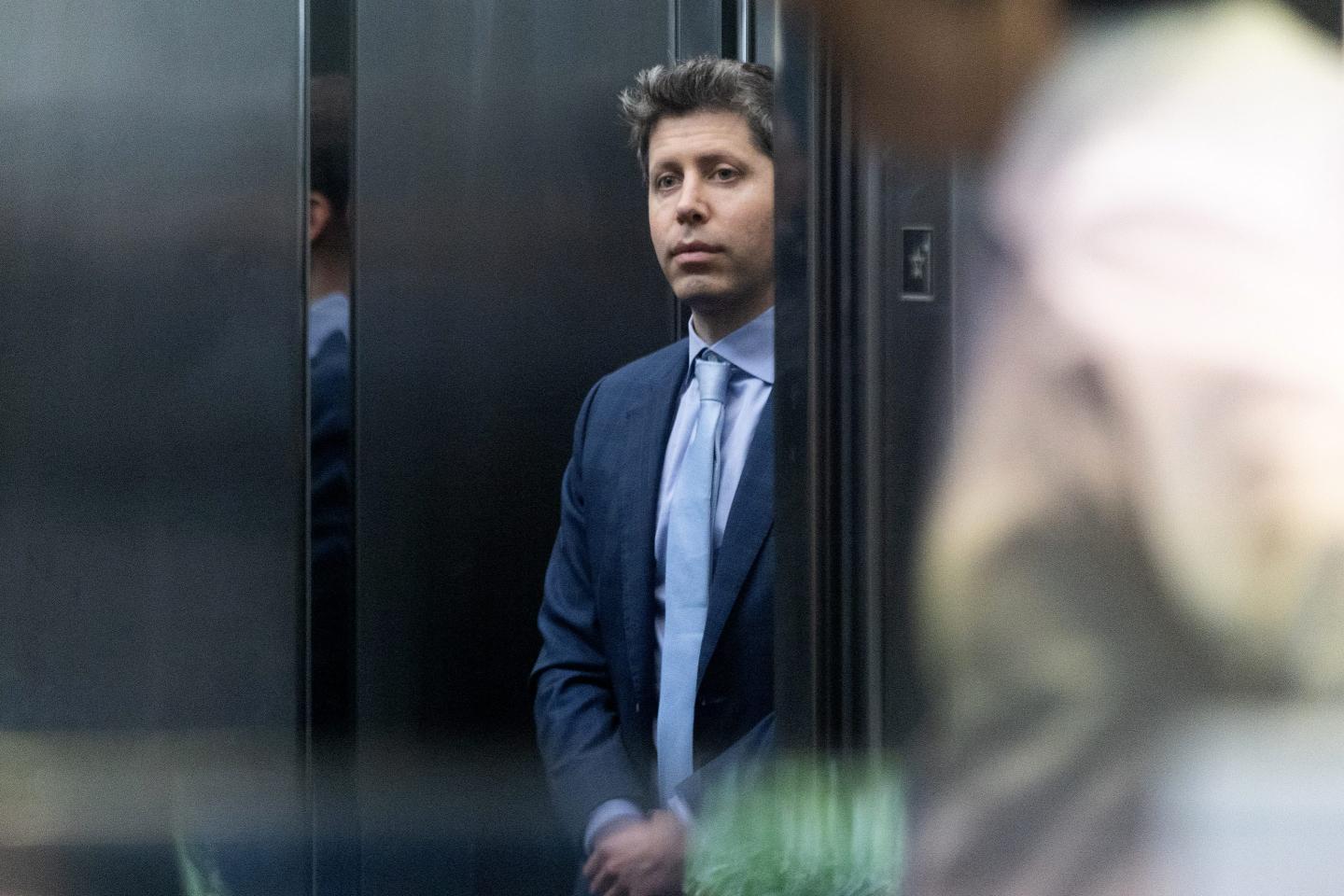 Sam Altman standing in a lift.