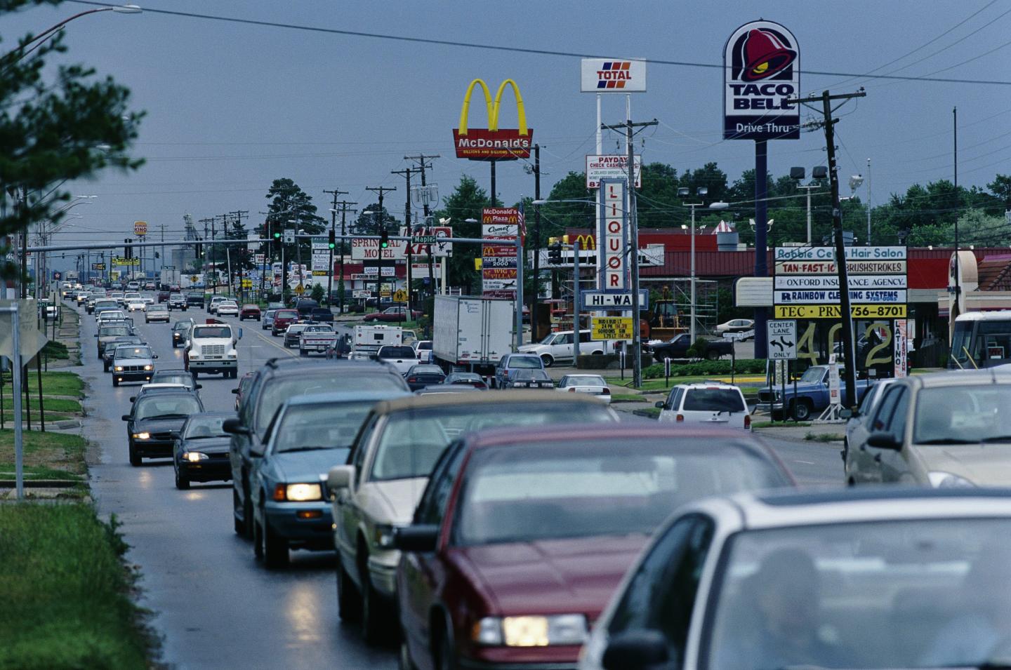 Photo of a line of cars passing various businesses