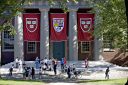 Harvard University banners hang in front of a building