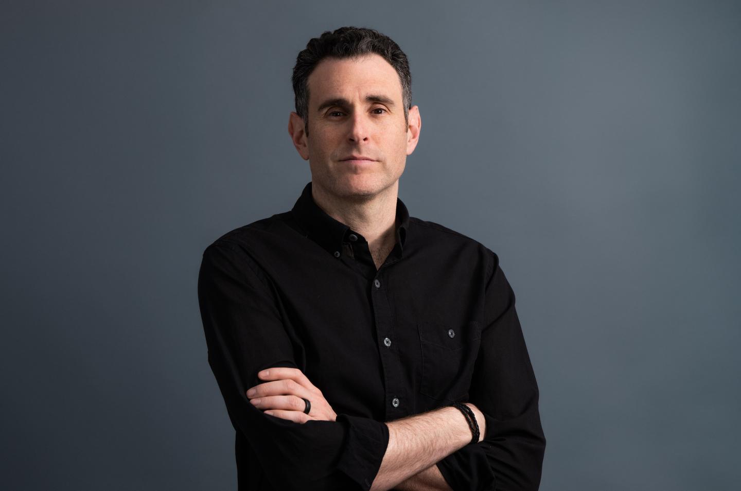 Alex Israel crosses his arms