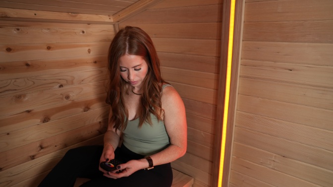 A woman inside the wooden walls of the Plunge Sauna
