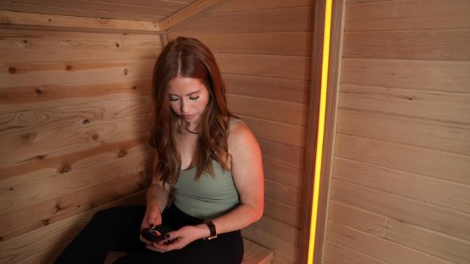 A woman inside the wooden walls of the Plunge Sauna