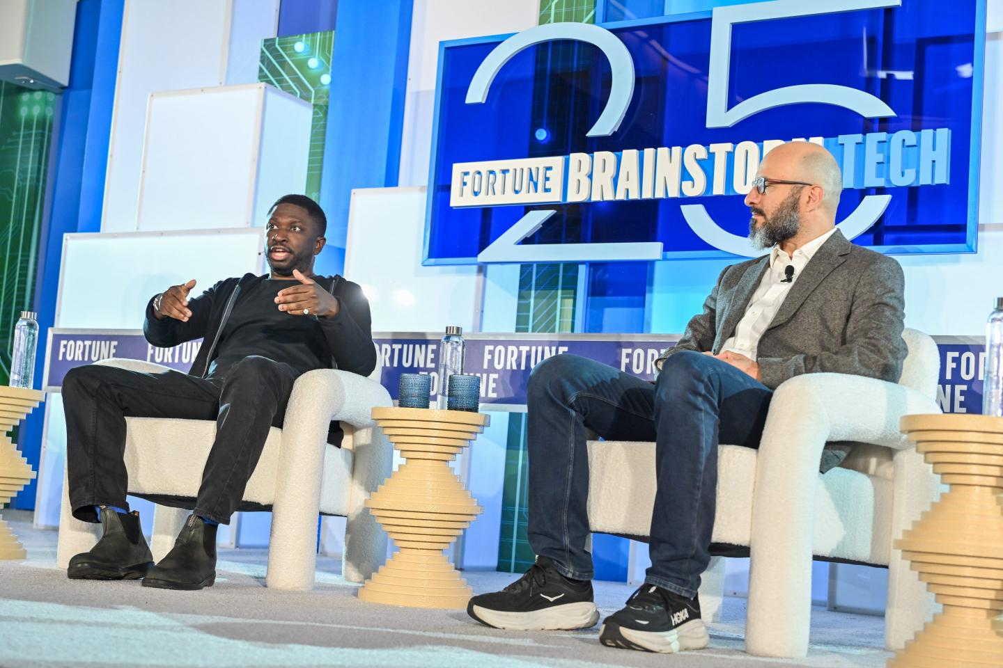 Two men sitting on chairs on a stage