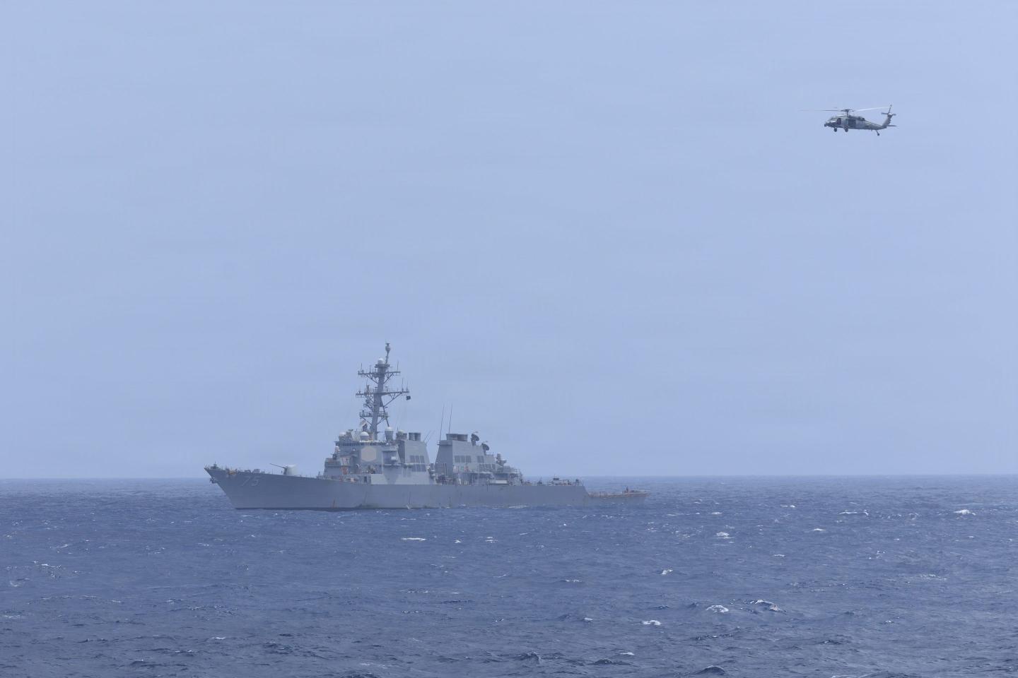 An MH-60S Sea Hawk, attached to Helicopter Sea Combat Squadron (HSC) 5, flies over Arleigh Burke-class guided-missile destroyer USS Donald Cook (DDG 75) while sailing alongside Nimitz-class aircraft carrier USS George H.W. Bush (CVN 77) while sailing in the Arabian Sea, June 17, 2026.