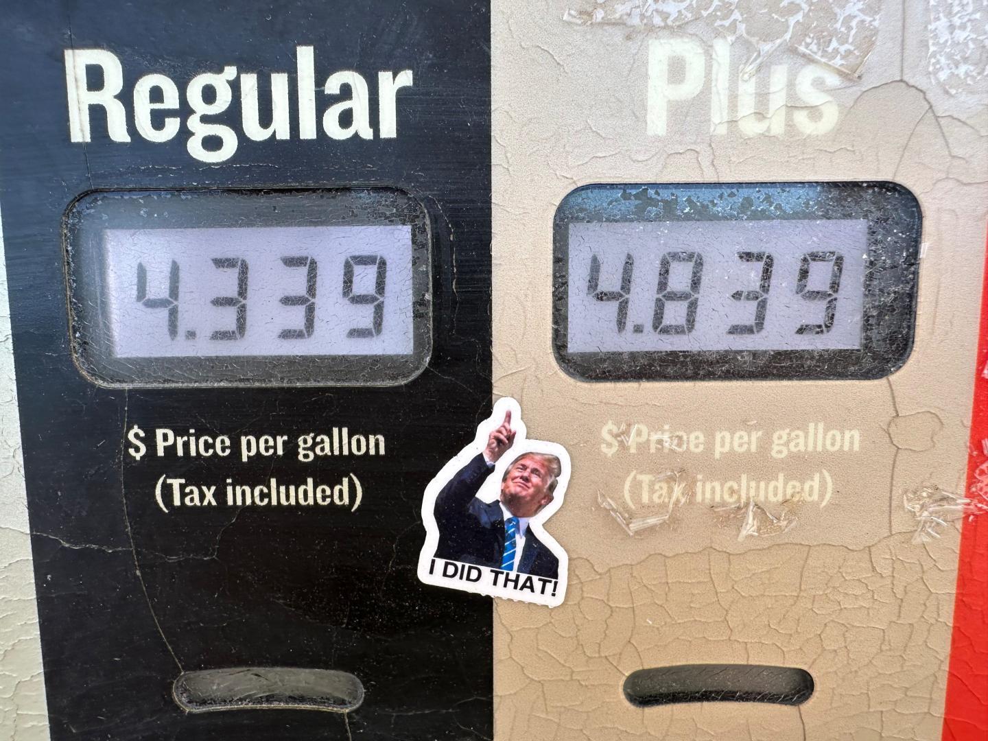 A sticker of President Donald J. Trump points to the electronically-posted prices for a gallon of regular or regular plus gasoline available at a Conoco station Saturday, May 30, 2026, in Denver.