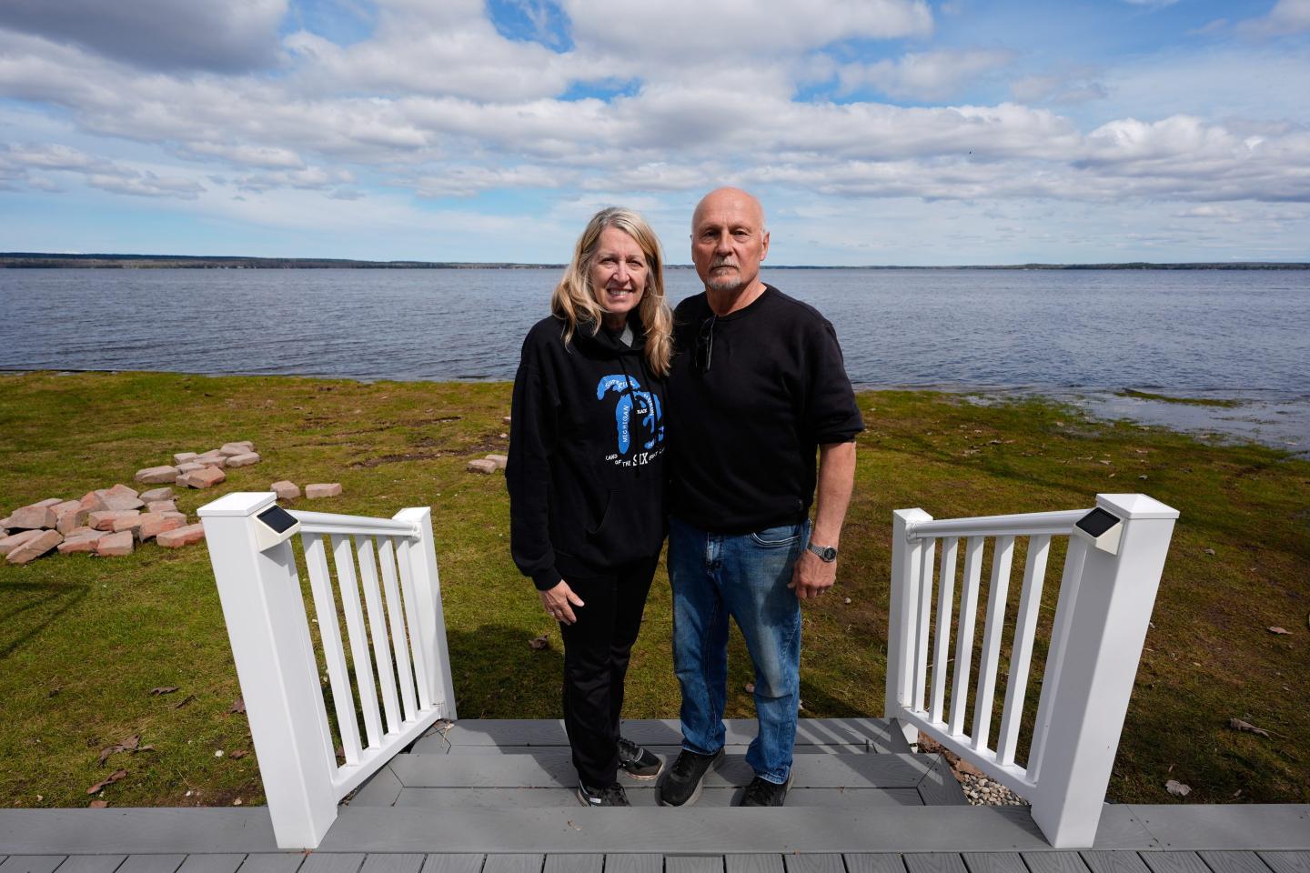 Tom and Diane Peterman pose outside their home at Black Lake on Wednesday, April 29, 2026, in Grant Township, Mich.
