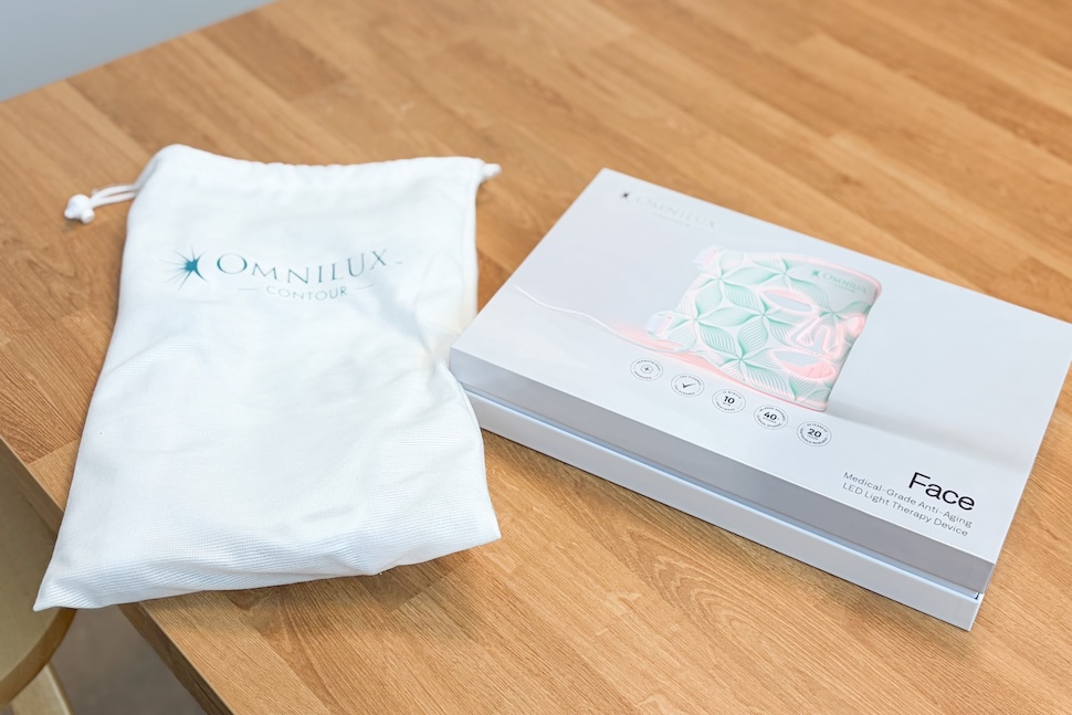 A box containing the Omnilux Contour Face mask. A travel bag sits next to it.