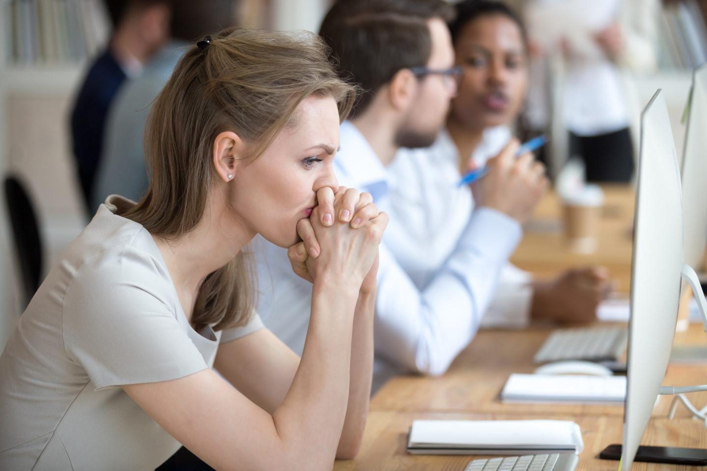 Upset frustrated and confused female worker folding hands on chin