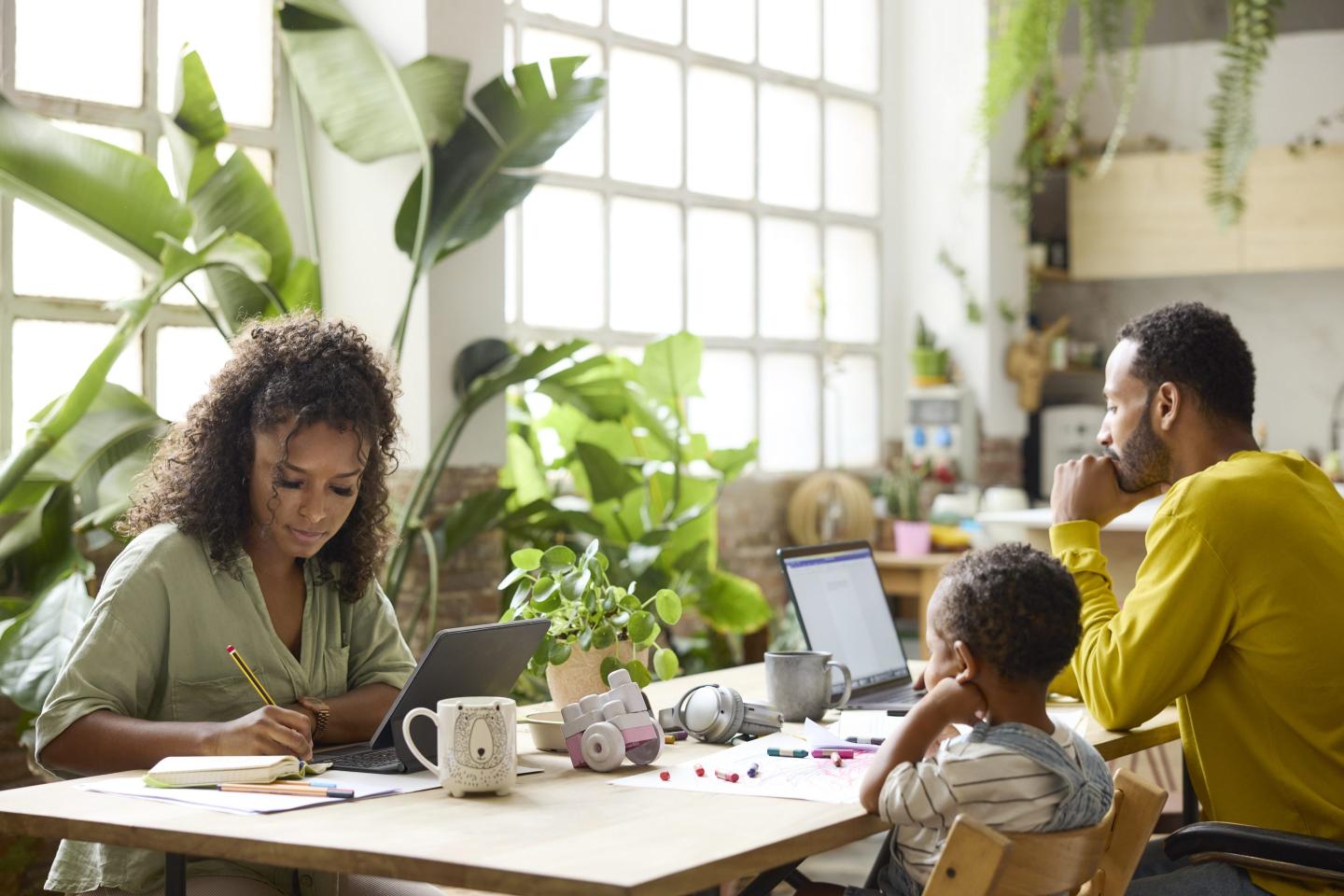 A mother and father work while their child plays