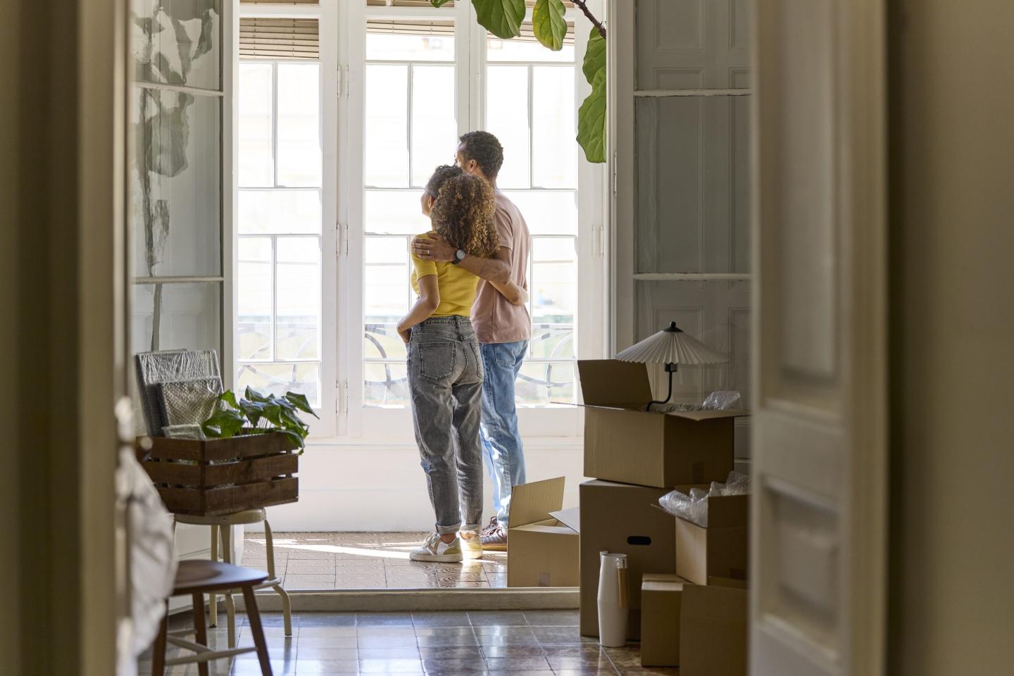 Young couple standing in a brightly lit home
