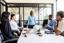 Senior businesswoman speaking to colleagues in modern conference room