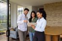 Young real estate agent with clients at house