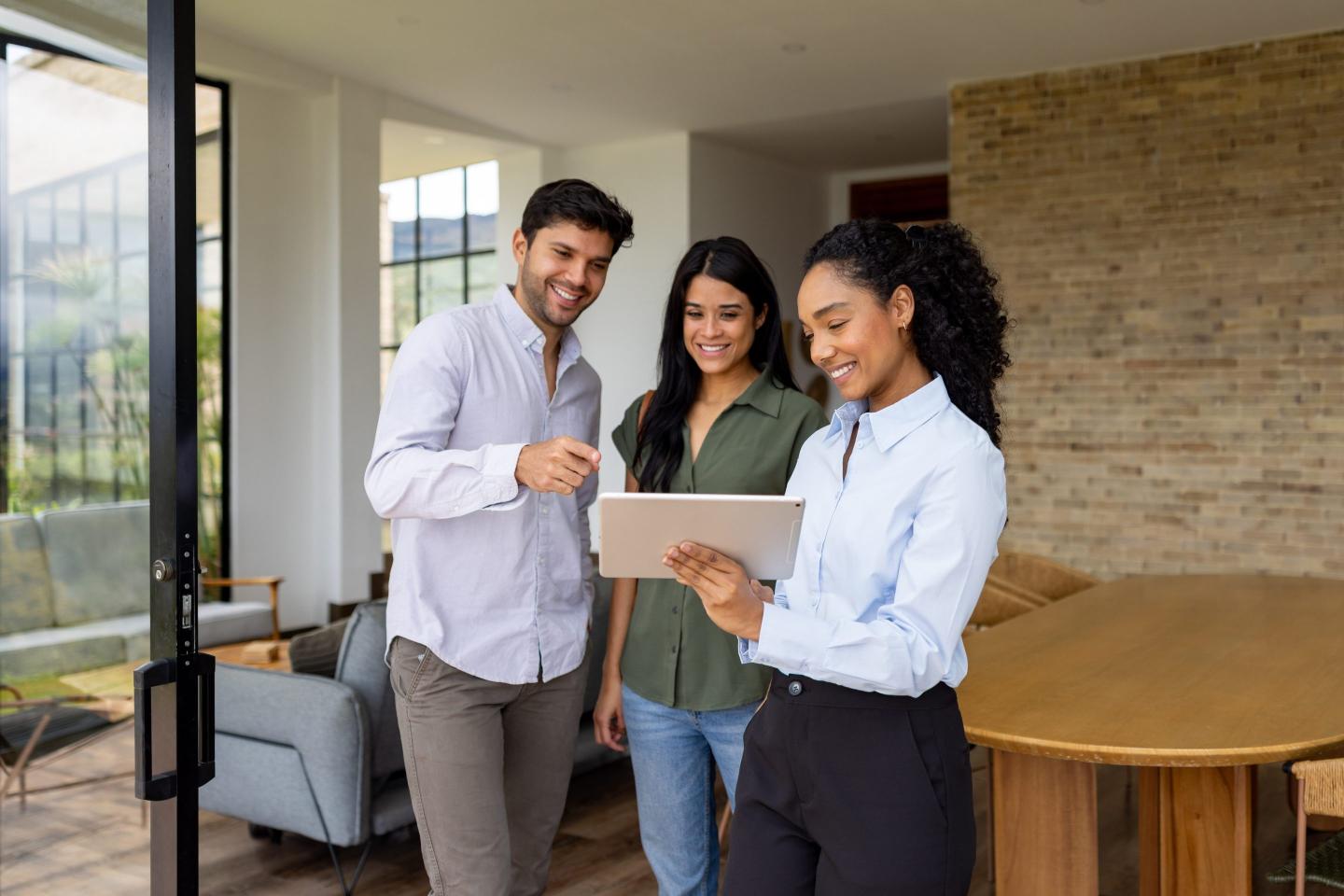 Young real estate agent with clients at house