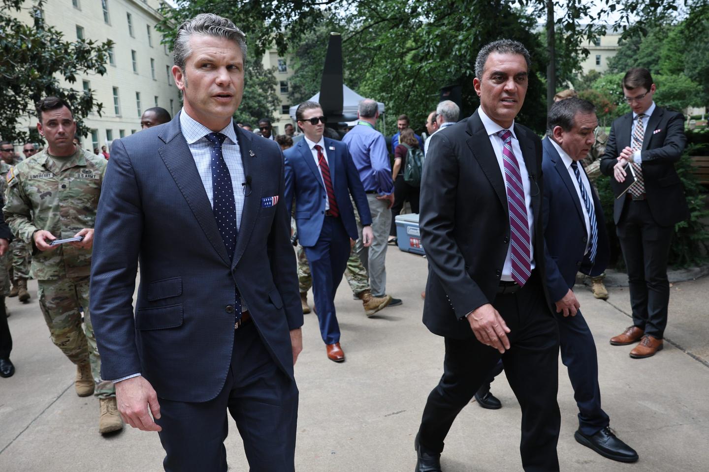 Pete Hegseth and Emil Michael walk next to each other.
